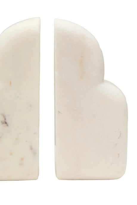 Close view of the Vela white marble bookends, showing the soft grey and blush markings in the stone.