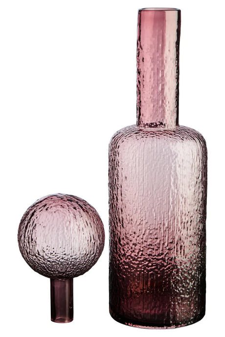 Pink glass bottle and separate spherical stopper on a white background