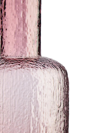 Close-up of a textured pink glass bottle on a white background