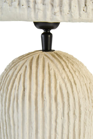 Close-up of a textured lamp with a white base and black fixture on a white background