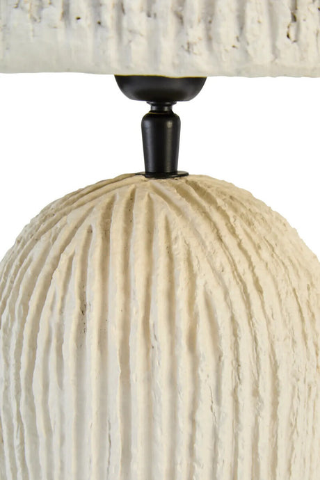 Close-up of a textured lamp with a white base and black fixture on a white background