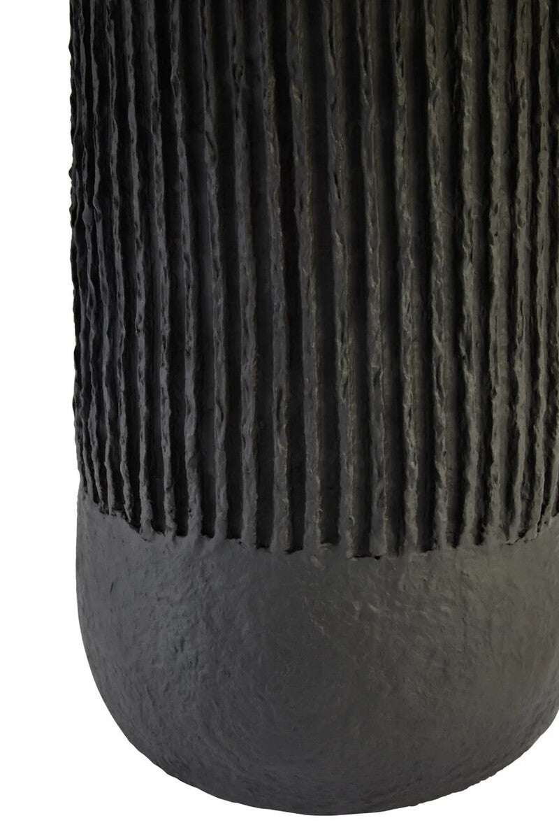 Base of a black ribbed table lamp on a white background