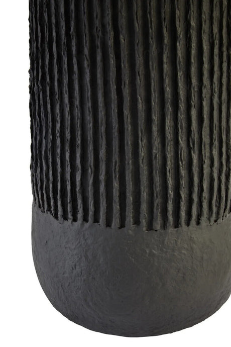 Base of a black ribbed table lamp on a white background