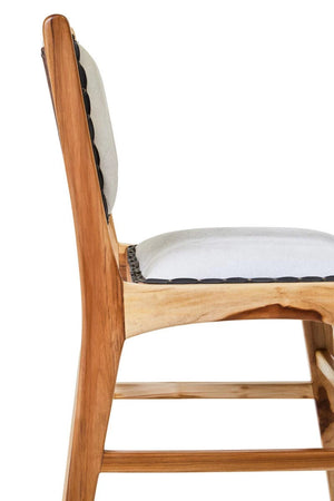 Side view of the Jakarta Cowhide and Teak Dining Chair, showing the padded cowhide seat and teak frame.