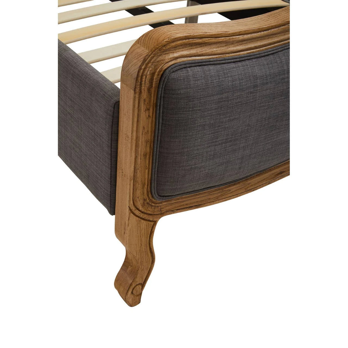 Close-up of a curved cabriole leg and carved oak corner on the Vienne Grey Fabric Super King Size Bed.