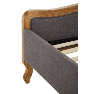 Close view of the Vienne bed footboard corner, showing the shaped oak frame, grey upholstered rail and cabriole leg.