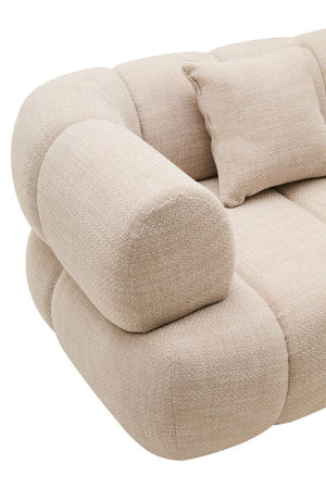 Armrest of a rounded cream sofa on a white background