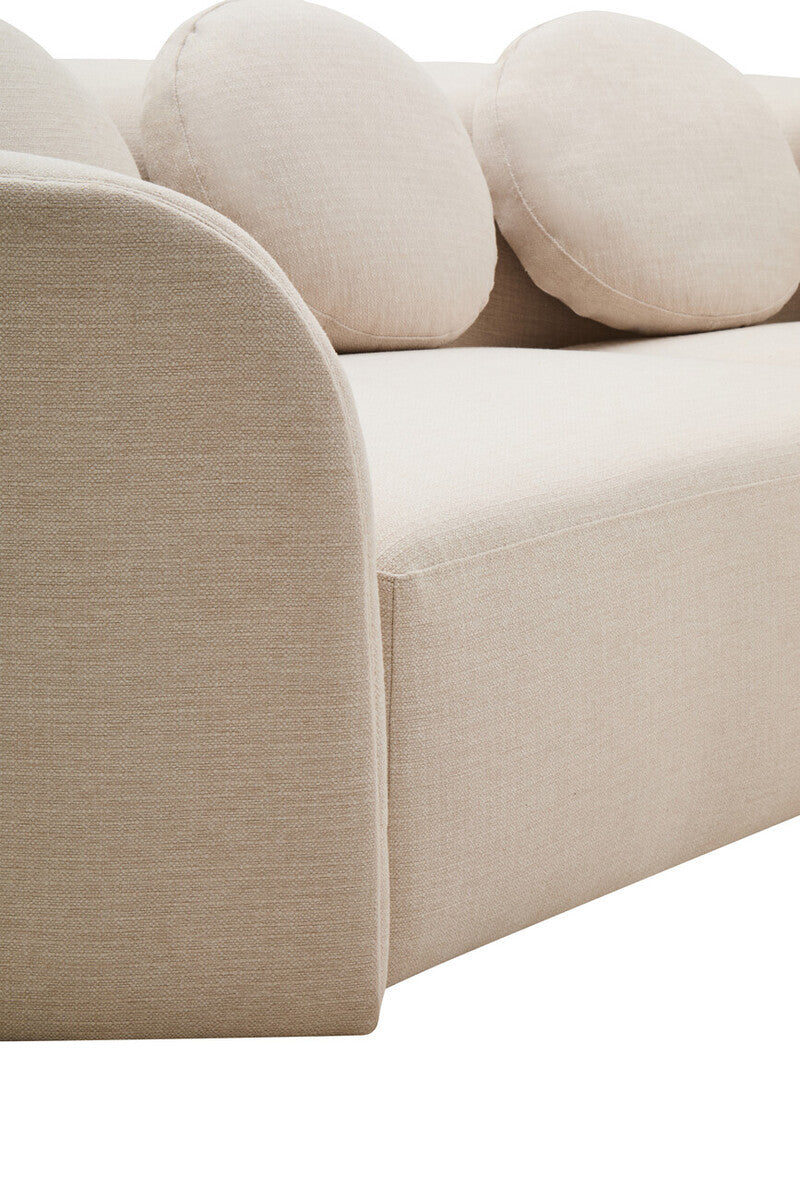 Close up of cream linen curved sofa with round cushions