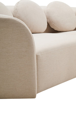 Close up of cream linen curved sofa with round cushions