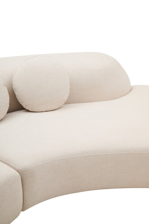 Cream linen curved sofa with round cushions on a white background
