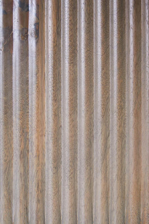 Close-up of the vertical reeding and grey-washed mango wood grain on the Hawthorn shelf unit's centre panel.