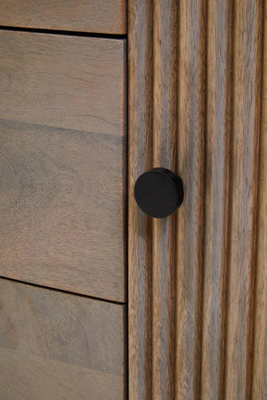 Close-up of a round black knob on a reeded door of the Hawthorn Grey Oval Sideboard.