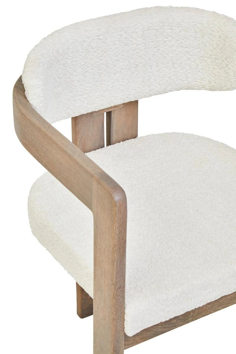 Close-up of the curved grey mango wood frame of the Hawthorn Dining Chair wrapping around the bouclé backrest.