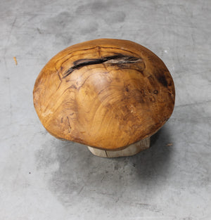 Wooden mushroom ornament on a grey surface