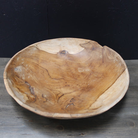 Wooden teak root bowl on a wooden background