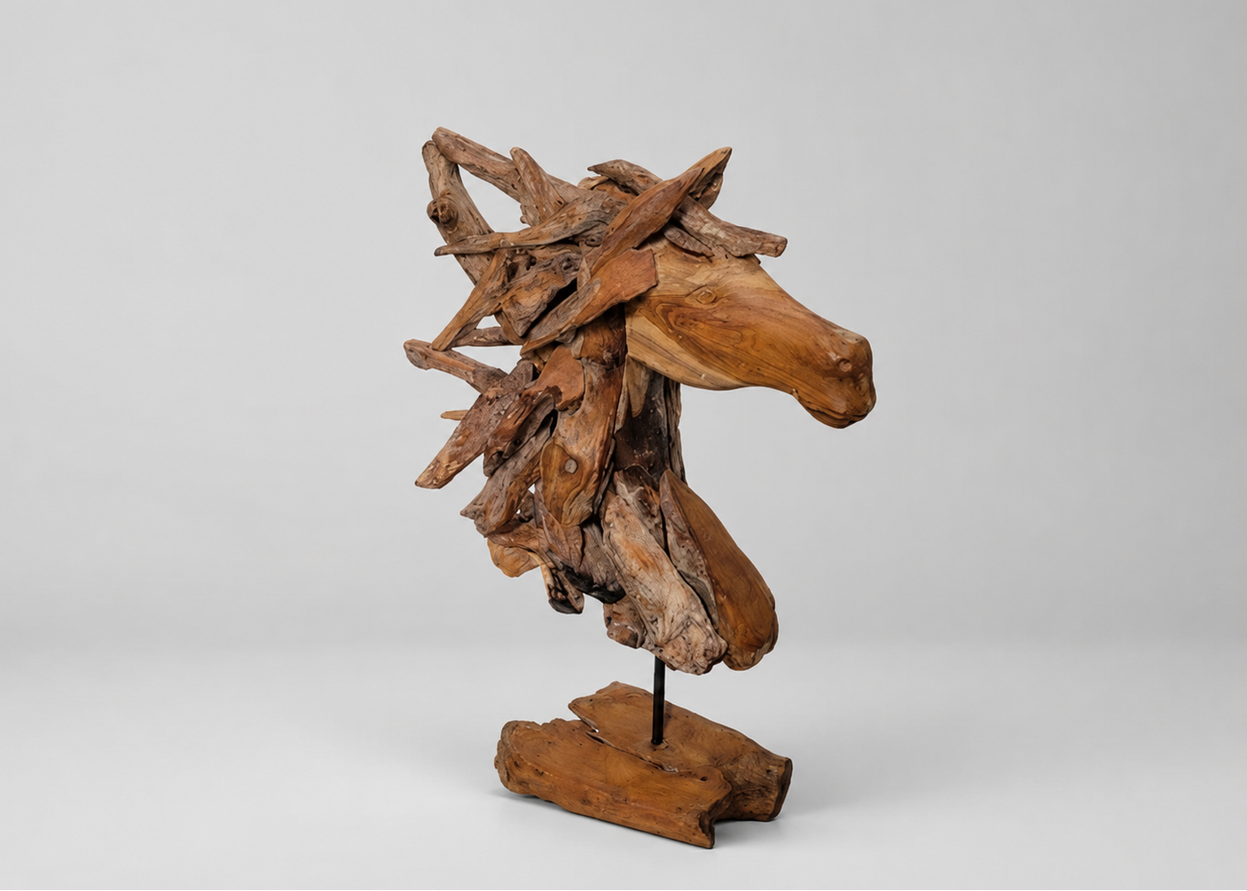 A rustic wooden horse head sculpture mounted on a matching stand, crafted from natural driftwood with visible grain and bark details, photographed against a neutral light gray studio background.