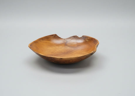 Teak root wooden bowl on a grey background