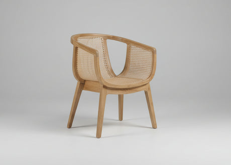 A modern accent chair with a light oak wood frame and natural woven cane backrest and seat, shown on a neutral gray background.