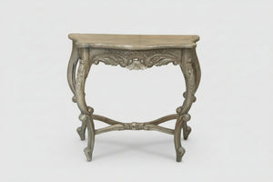An ornate console table with a distressed gray wood finish, featuring carved details on the apron and legs, set against a plain light gray background.