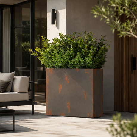 Decorative planter with green plants on a patio area with outdoor furniture.