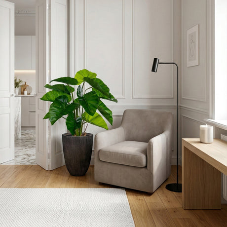 Modern living room with a grey armchair, potted plant, and standing lamp.