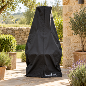 Buschbeck Masonry Barbecue Full Cover in black over a masonry barbecue on a stone terrace, between potted olive trees, lavender and a dry stone wall