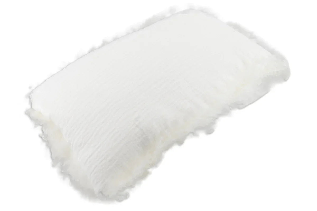 Rectangular White Linen Cushion With Sheepskin Trim shown at an angle, with its crinkled linen front and fluffy sheepskin trim