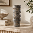 Cairn Forest Green Marble Vase with its stacked pebble silhouette, styled on a fluted stone console beside linen books, a stone bowl and olive branches.