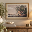 Flora & Fauna Curlews print in a beaded oak-finish frame above a rustic wooden sideboard with olive branches in a stone jug, a linen table lamp and books