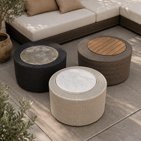 Three round woven outdoor coffee tables with stone-look top surfaces in black, beige, and brown tones, arranged on a rug in front of a sectional sofa.