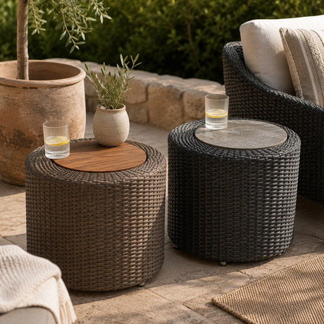 Concentric outdoor wicker side tables with offset wood and slate inserts styled on a garden patio with drinks, greenery and outdoor seating.