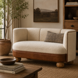 Cream boucle sofa with buffalo leather detail and round mango wood feet in a cosy living room setting