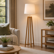 Wooden cross floor lamp in a living room setting with a sofa, coffee table, and decorative items.