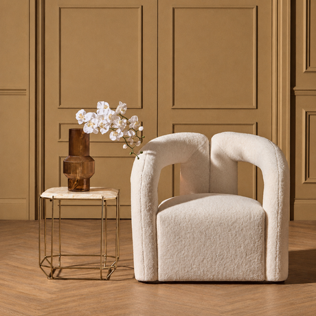 Diana cream boucle statement armchair in a room with a wooden floor and beige walls.