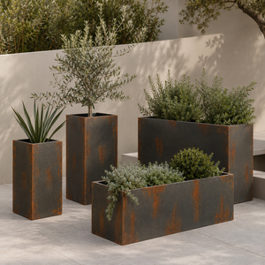 A set of four outdoor planters with rust decorative detail in a Mediterranean style garden setting with beige walls and plants