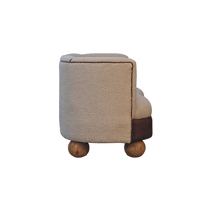 Side view of a cream boucle sofa with mango wood round legs