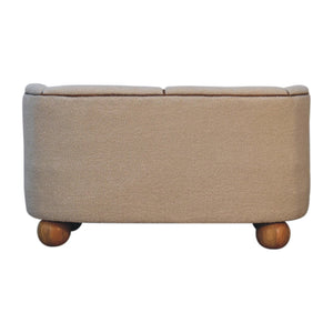Back view of a cream boucle sofa with round mango wood feet