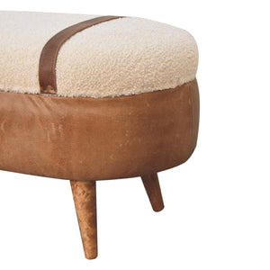 Close up of one side of a beige boucle seat bench with brown buffalo leather straps and a wooden base with four legs.