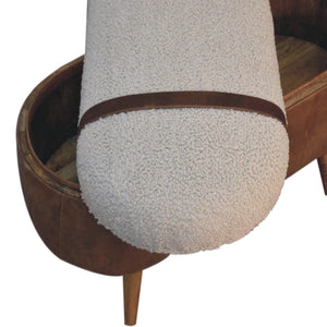 A beige boucle seat bench with brown buffalo leather straps and a wooden base with four legs with the removable top sitting across the base