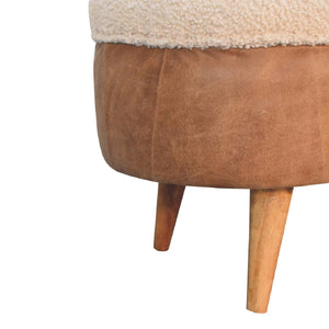 Close up of the leather section of a beige boucle seat bench with brown buffalo leather straps and a wooden base with four legs.