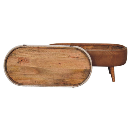 A beige boucle seat bench with brown buffalo leather straps, a wooden base with four legs and a removable top sitting against the side