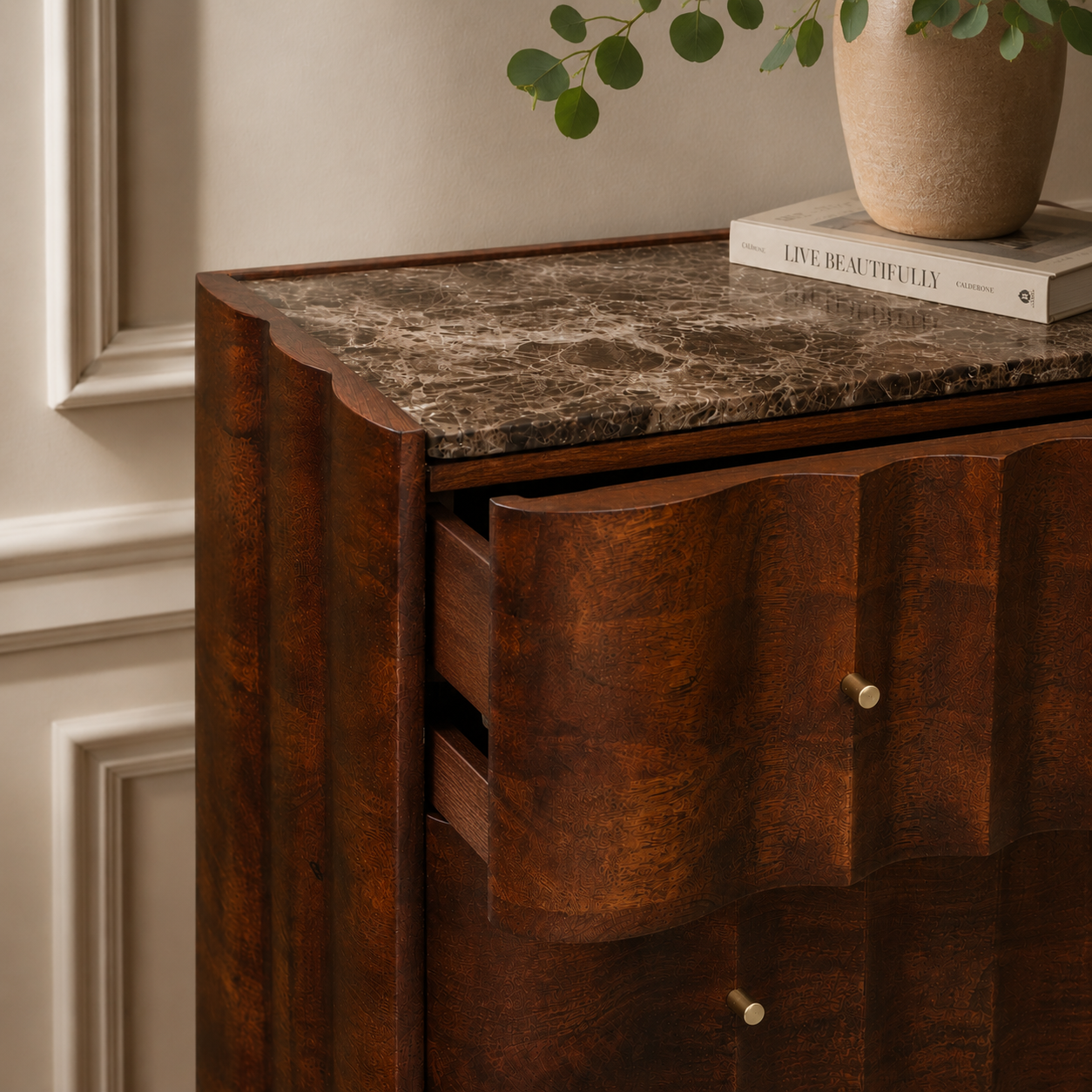 Wooden chest of drawers with marble top and decorative items in a home setting