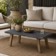 Charcoal indoor outdoor coffee table with wooden legs styled in a neutral living space with a cream sofa, woven rug and natural textures.