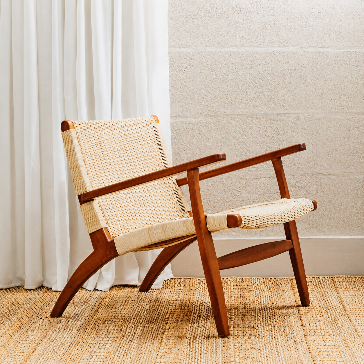 Armchair with mahogany wood frame and natural woven back and seat against a neutral background