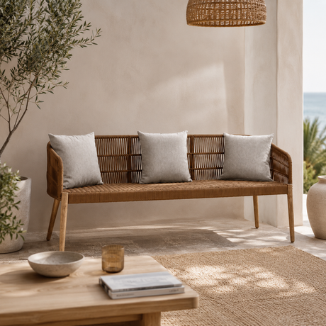 Woven bench with grey cushions in a modern living room setting.