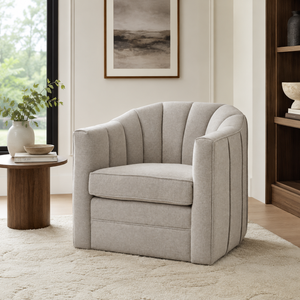 Grey armchair in a living room setting with a window and bookshelf in the background.