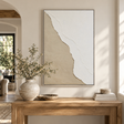 Linea textured plaster canvas in white and sand above a rustic wooden console table with olive branches in a stone vase, a wooden bowl and books
