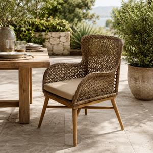 Woven outdoor dining chair with cushion by a wooden table outdoors