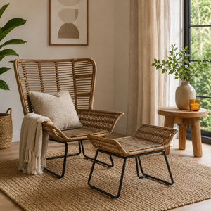 Marano natural rattan lounge chair and footstool with a pillow and blanket in a cosy living room setting.
