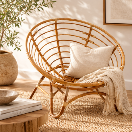 Marano papasan natural rattan chair with a pillow and blanket in a cosy room setting
